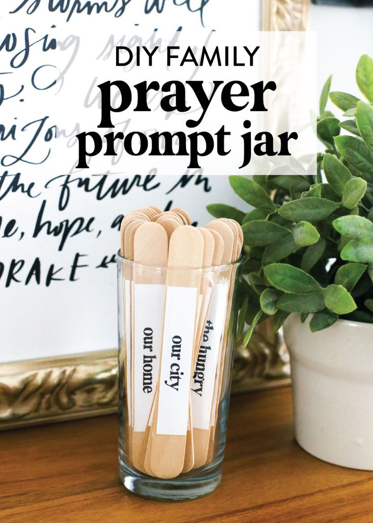 some wooden sticks are sitting in a glass on a table next to a potted plant