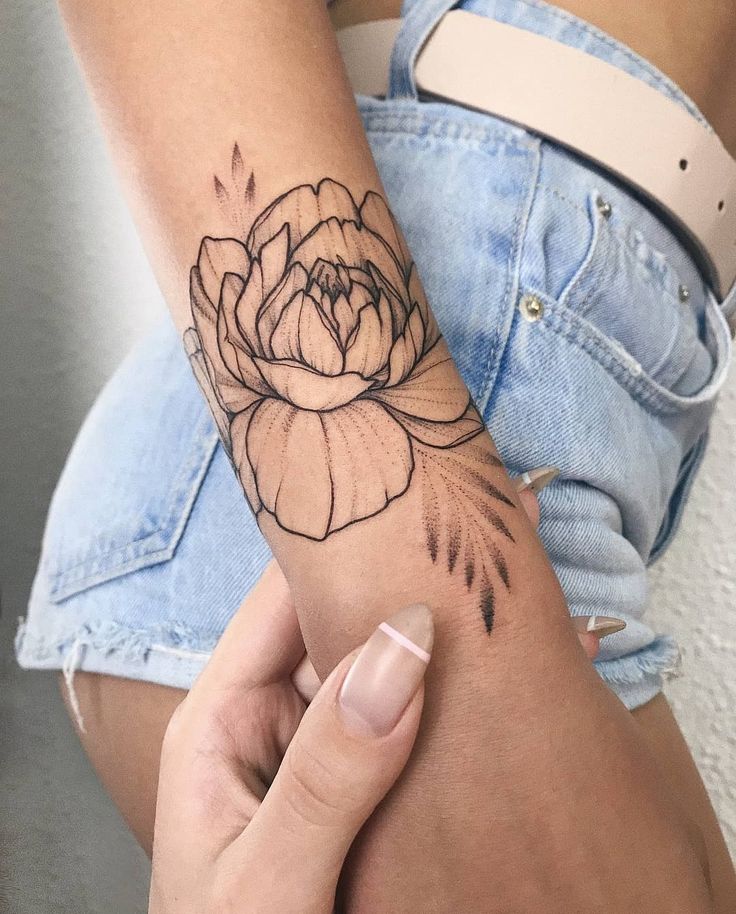 a woman's arm with a flower tattoo on it