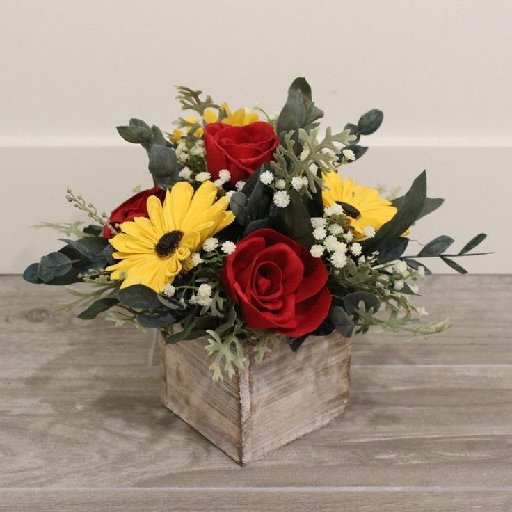 a wooden box filled with red and yellow flowers