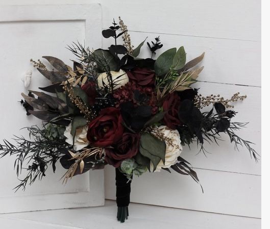 a bridal bouquet with red and white flowers on the side of a door frame