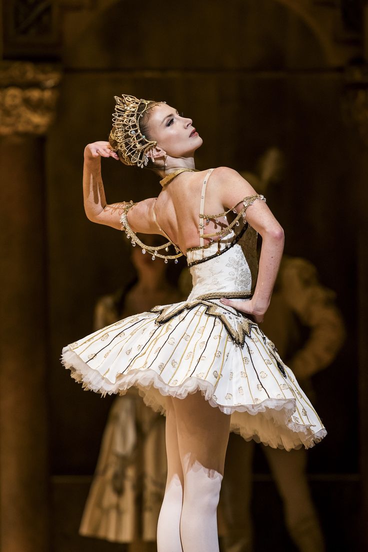 a woman in a white dress is performing on stage