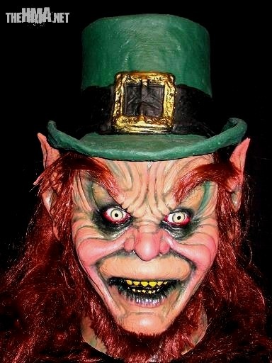 a close up of a person wearing a green top hat and clown make - up