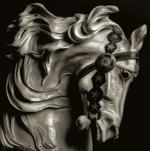 a black and white photo of a statue of a horse with stars on it's head