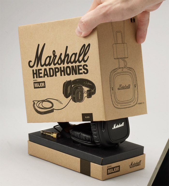 a cardboard box with headphones in it being held by a person's hand