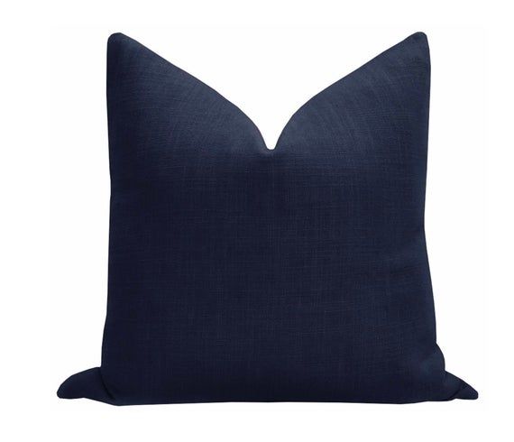 a dark blue pillow on a white background