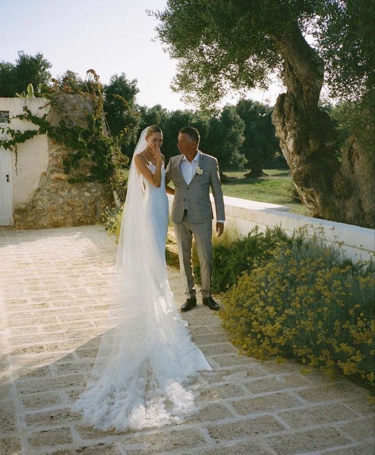 the bride and groom are walking down the path to their wedding ceremony at villa san clementi