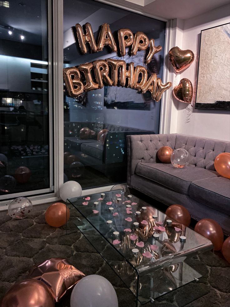 a living room filled with balloons and confetti on top of a glass table