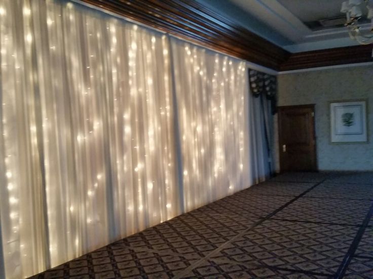 an empty room with lights on the wall and curtains in front of the window that are closed