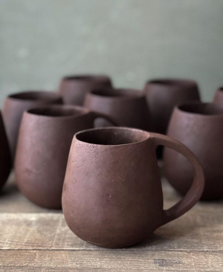 several brown cups sitting on top of a wooden table