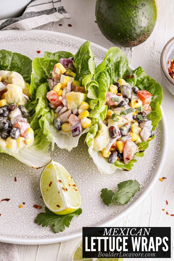 lettuce wraps with black beans, corn and avocado on a white plate