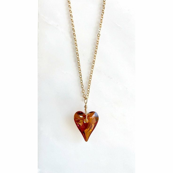 Hanging from an 18" gold plated chain is a gorgeous Swarovski Crystal Heart. The shape is called wild heart by Swarovski and it has almost an organic shape to it. Radiating with sparkle the 17mm pendant is called red magma which looks like a flame is burning within. I hand-wrapped the beaded crystal with gold-filled wire for a total length of about 1.25". This bewitching piece is finished with a warm gold patina, adding a touch of timeless luxury to an already sensational accessory. This truly u Necklace Gold Chain, Crystal Heart Necklace, Swarovski Crystal Hearts, Orange Necklace, Wild Heart, Hand Wrap, Red Crystals, Wild Hearts, Crystal Heart