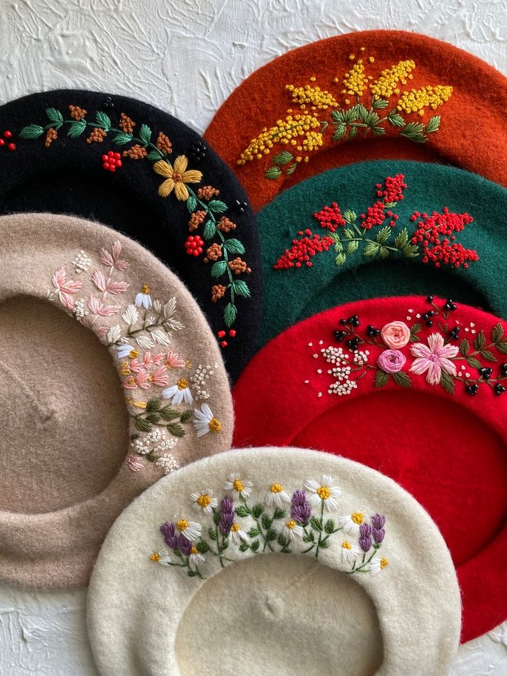 several different colored hats with flowers on them