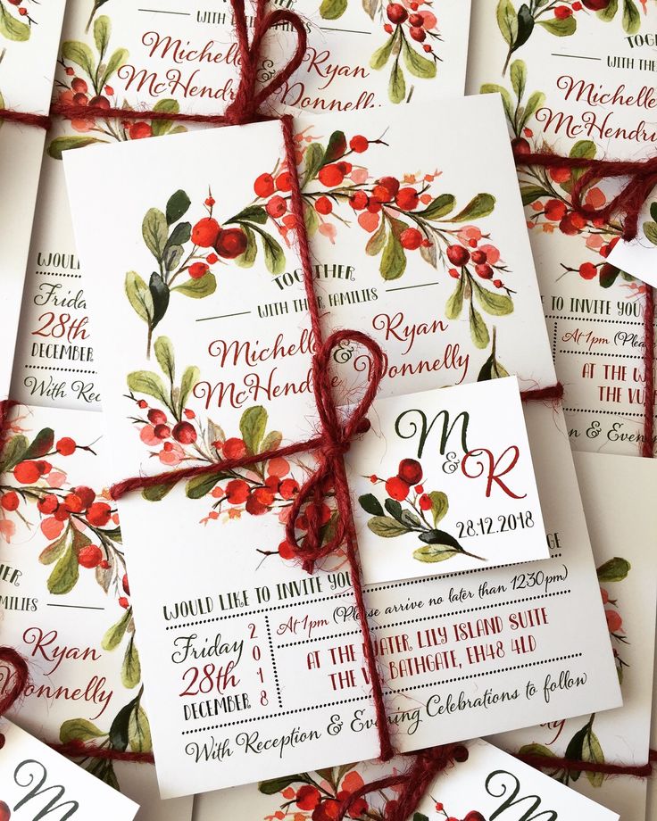 wedding stationery with red berries and green leaves on them, tied in twine