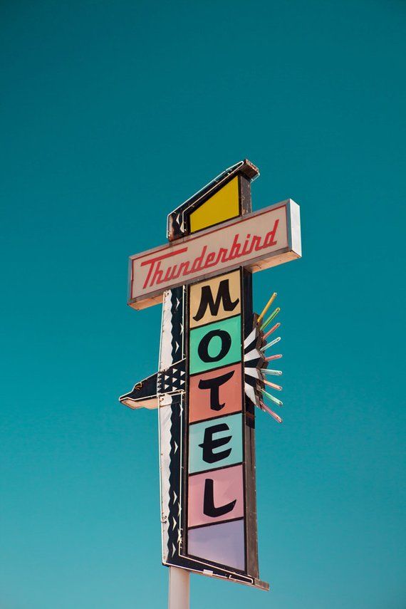 a motel sign with the word thunderbird on it's side against a blue sky