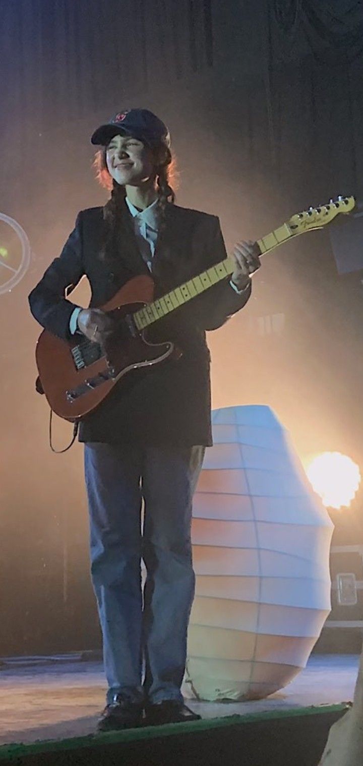 a man standing on stage with a guitar