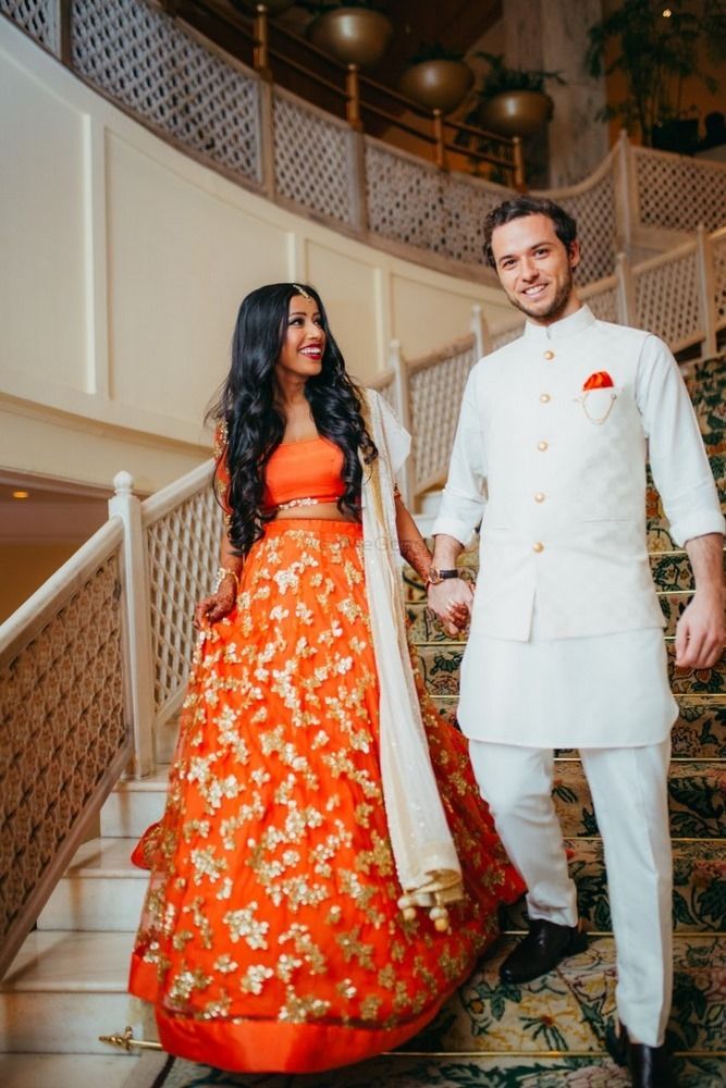 a man and woman standing next to each other in front of some stairs holding hands