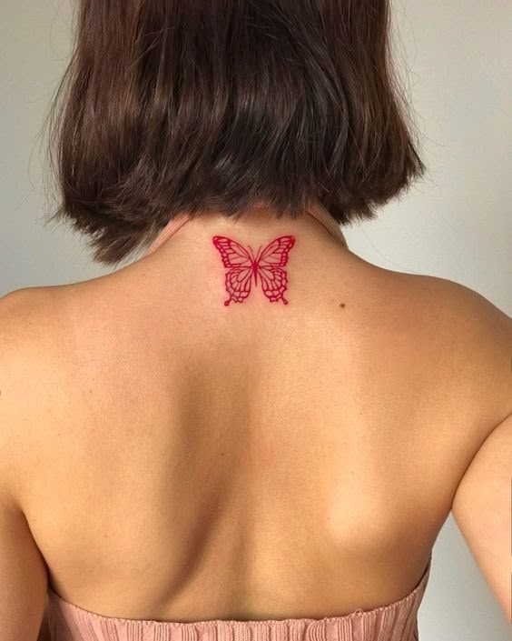 the back of a woman's neck with a butterfly tattoo on it