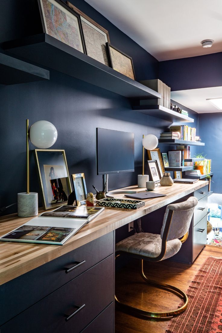 a home office with blue walls and wooden flooring, along with an area rug on the floor