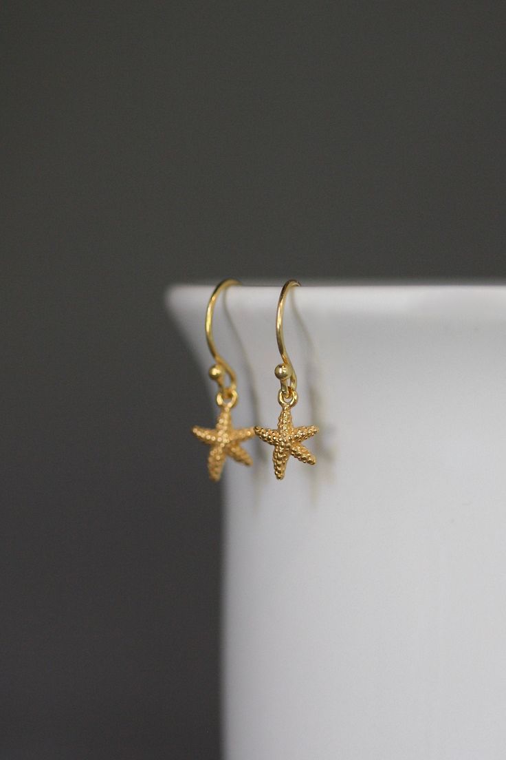 "Dainty and petite 24k gold vermeil starfish charms dangle from 18k gold vermeil balled earwires. Perfect small earrings for anyone of any age. Gold star charms: 8x9mm Total length of earrings: almost 1\" All gold is gold vermeil. As the owner, maker, designer, and curator of this shop, I take great pride in providing you with jewelry that you will love to wear everyday, for special occasions, and for many years to come. Please read my Shop Policies which contains important information regarding 14k Gold Filled Earrings With Star Charm As Gift, Gold Starfish Shaped Dainty Jewelry, Dainty Starfish Gold Jewelry, Everyday Yellow Gold Earrings With Star Charm, Dainty Gold Starfish Jewelry, Yellow Gold Starfish Earrings For Gift, Elegant Gold Star Earrings, Elegant Hypoallergenic Star Earrings, Gold Starfish Earrings Nickel Free