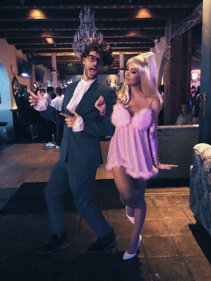 a man and woman dressed up in costume dancing on the dance floor at a party