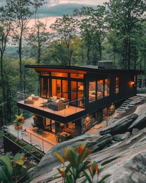 a large house sitting on top of a cliff next to a lush green forest covered hillside