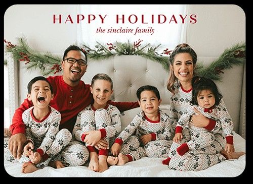 a family in matching christmas pajamas on a bed with the words merry christmas written above them