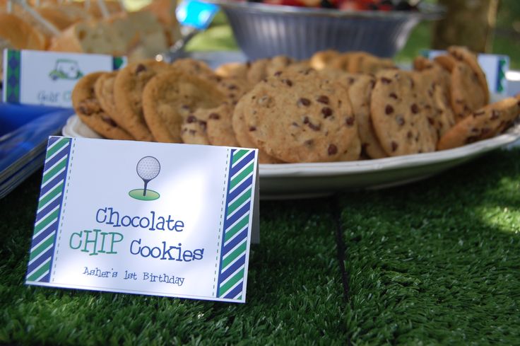 chocolate chip cookies are on the table at a golf themed birthday party, with place cards