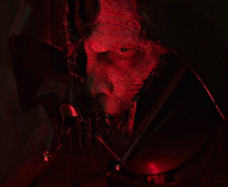 a man with red light on his face in the dark