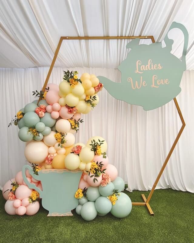 there is a cake made out of balloons and flowers on the table with a sign that says ladies we love