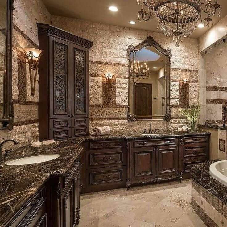 a luxurious bathroom with chandelier and marble counter tops