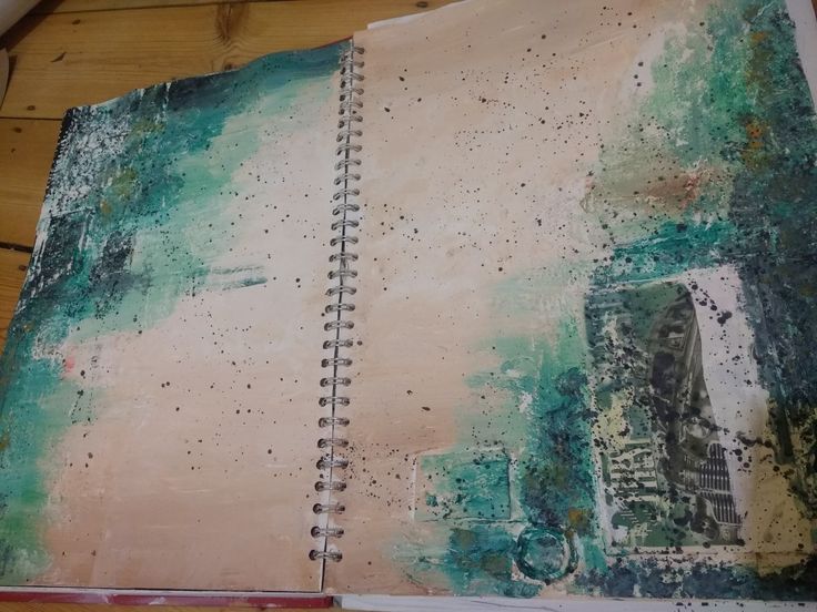 an open book with lots of dirt on the pages and some watercolors all over it