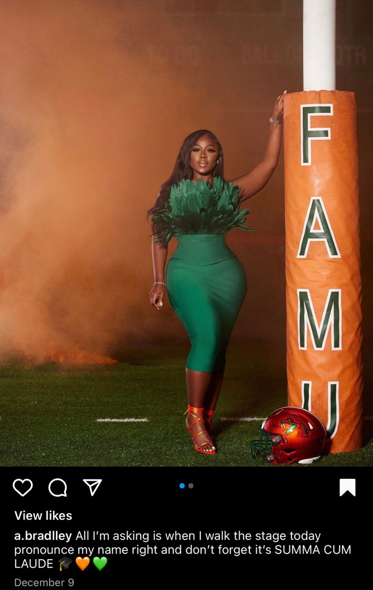 a woman in a green dress standing next to a tall orange sign with the word fam on it