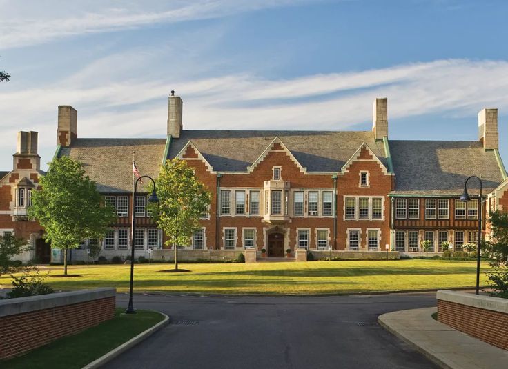 a large brick building sitting on top of a lush green field