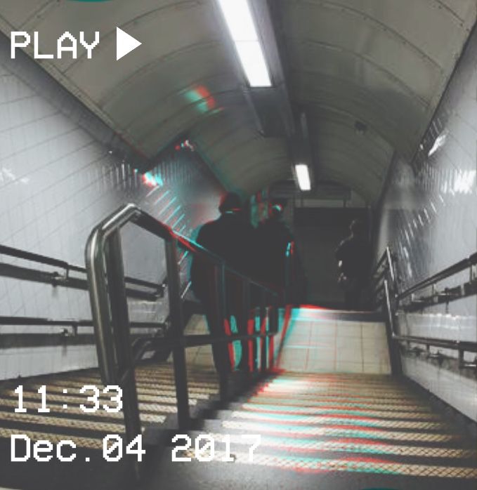 a man is walking down an escalator in a subway station with red and blue lights