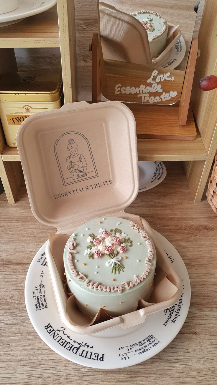 there is a small cake in the box on the table with it's lid open