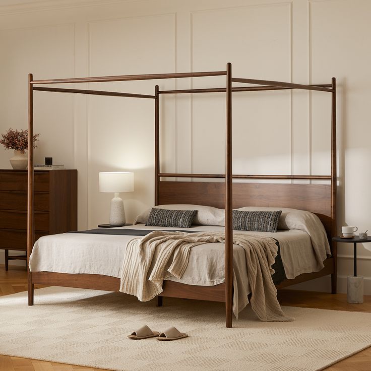 a bedroom with a four post bed and white walls