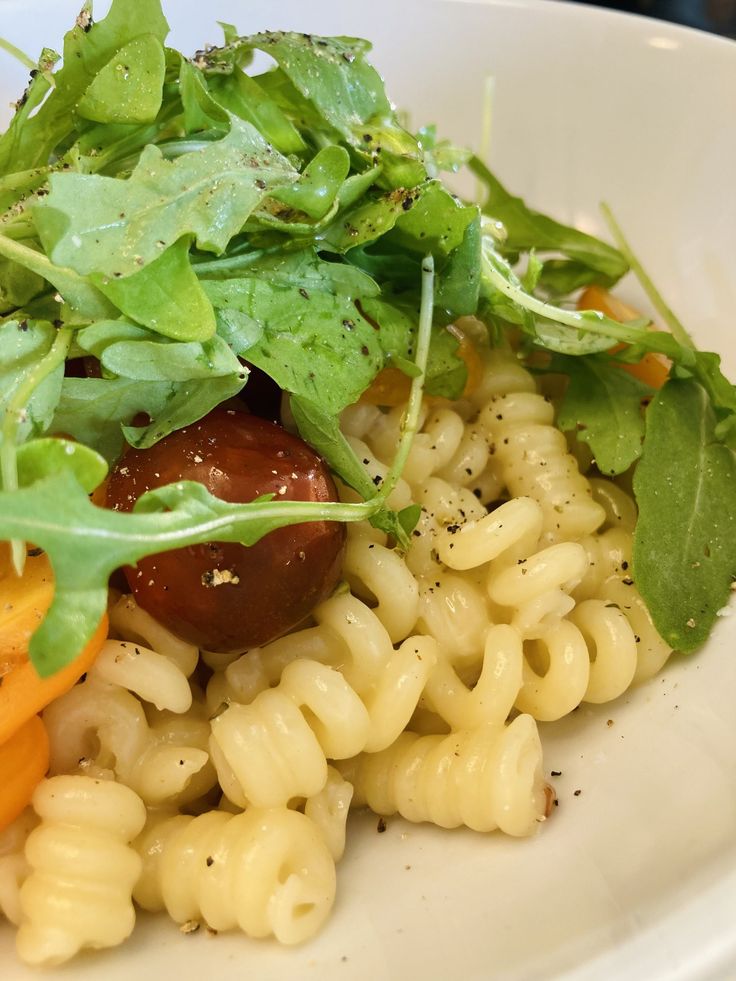 a white plate topped with pasta and vegetables