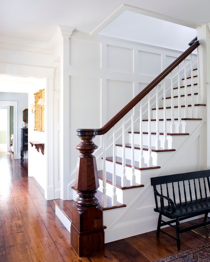 a wooden bench sitting next to a stair case