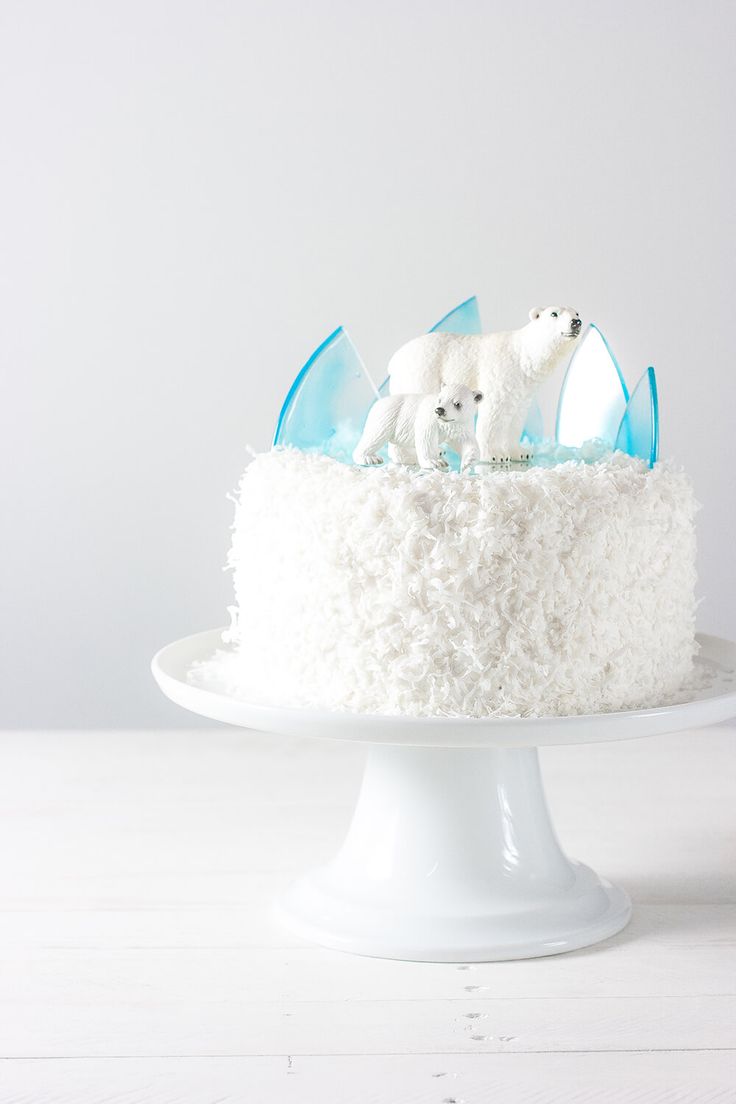 a white cake with frosting and two polar bears on top