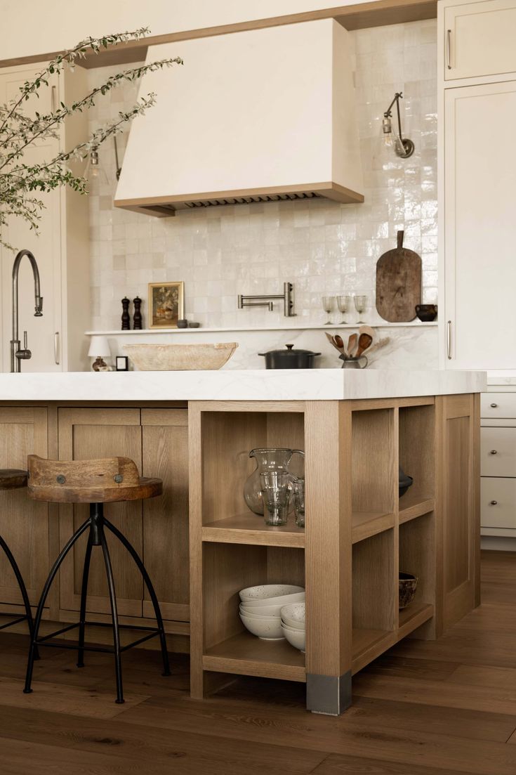 a kitchen with an island and stools in it