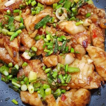 chicken and vegetable stir fry in a wok with water droplets on the side, ready to be eaten