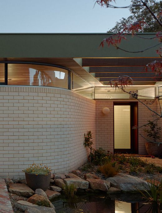 a brick house with a pond in the front yard