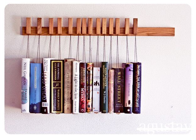 a book rack with books hanging from it's sides and two strings attached to the wall