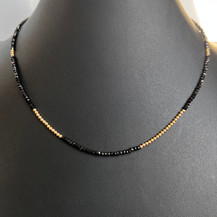 This luxe strand necklace crafted with 14K gold and faceted black spinel, and finished with a lobster clasp offers effortless style. Wear alone or layer for a fashion-forward look that is sure to turn heads. Beaded necklace with faceted black spinel gemstones 14K yellow gold beads + findings Lobster clasp closure shipping : allow up to a week from date your order was placed for shipping Minimalist Yellow Gold Jewelry With Black Spinel, Faceted Black Spinel Necklace, Dainty Gold Necklace With Black Beads, Minimalist Black Jewelry With Faceted Beads, Minimalist Black Spinel Necklaces, Minimalist Black Spinel Necklace, Black Beads Necklace, Gold Gemstone Necklace, Gold Jewellry