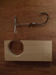 a fishing hook is attached to a piece of wood that has been cut in half