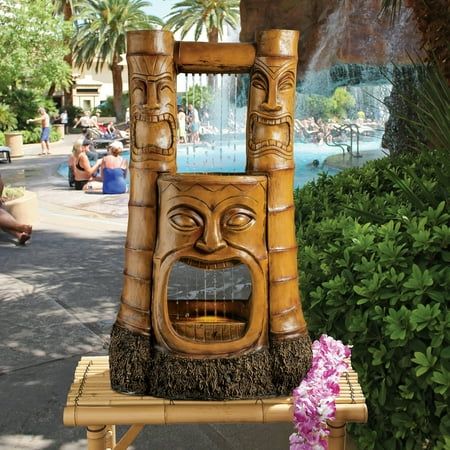 a wooden fountain with a face on it