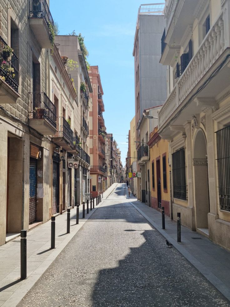 an empty city street with buildings and balconies on both sides, in the daytime