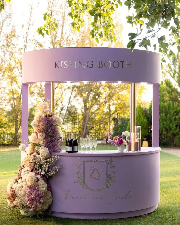 a purple kiosk with flowers and wine glasses