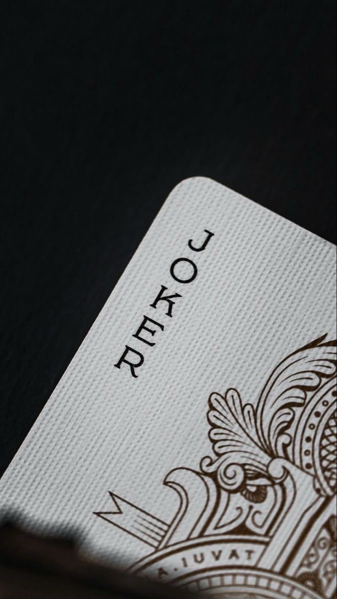 a close up of a playing card with the word joker written in black on it