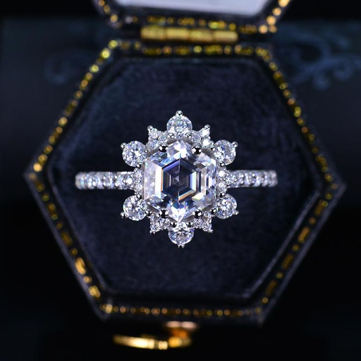 an engagement ring in a velvet box with gold trimmings and diamonds on it